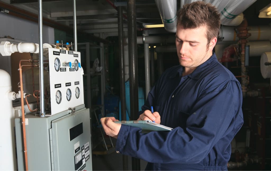 HVAC Technician Inspecting Air Conditining Unit with a Clipboard in Hand