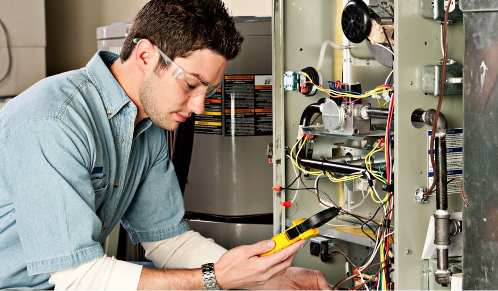 HVAC Employee checking on an HVAC unit in a residential home