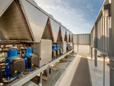 Commercial Heating and Cooling Building Chillers lined up on a Rooftop