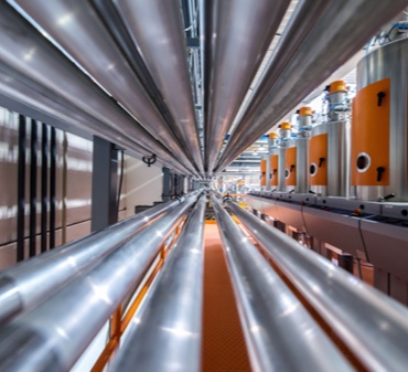 A perspective shot of siilver gas piping in an industrial building