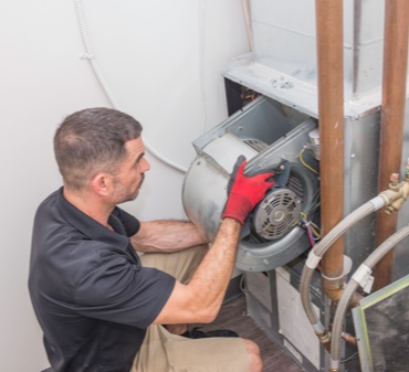 HVAC Technicion does preventative maintenance on a HVAC unit