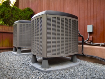 Outdoor Air Conditioning HVAC Unit on a Slab of Concret in an outdoor courtyard.