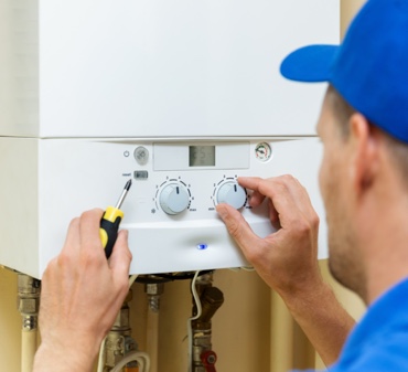 Technical Hot and Cold HVAC Technicion Fixing a Residential Boiler