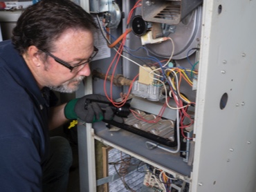Heating and Air Technician working on a residential furnace